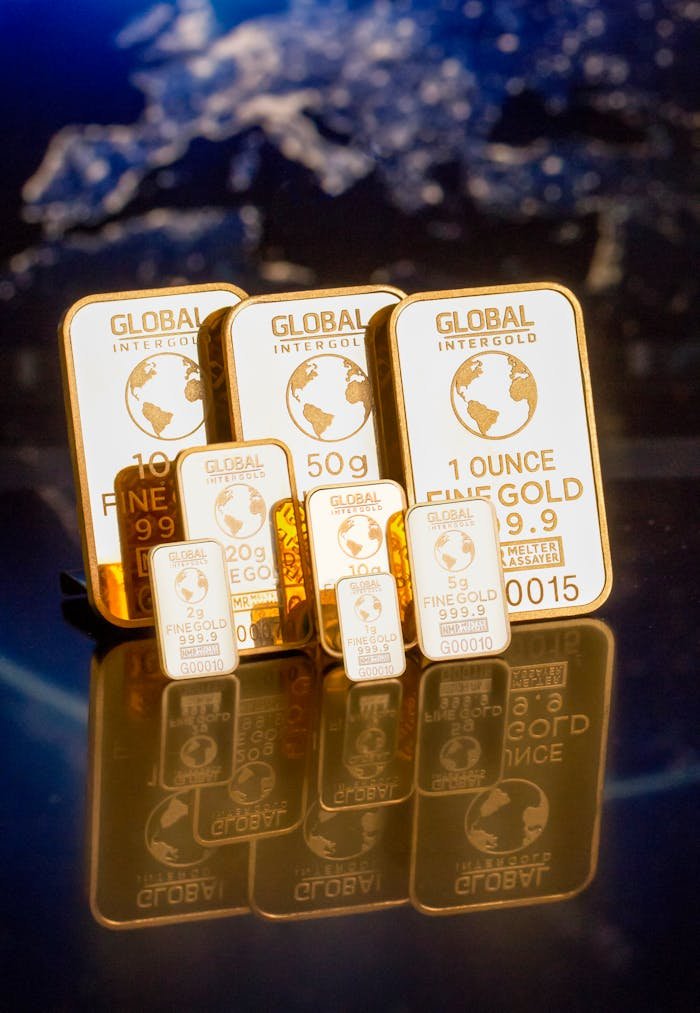 about-03 Collection of gold bars featuring a global map and weight inscriptions.